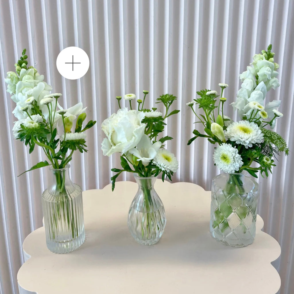 Three glass vases with white and green floral arrangements, suitable for event or a party. Kenmore Village Florist