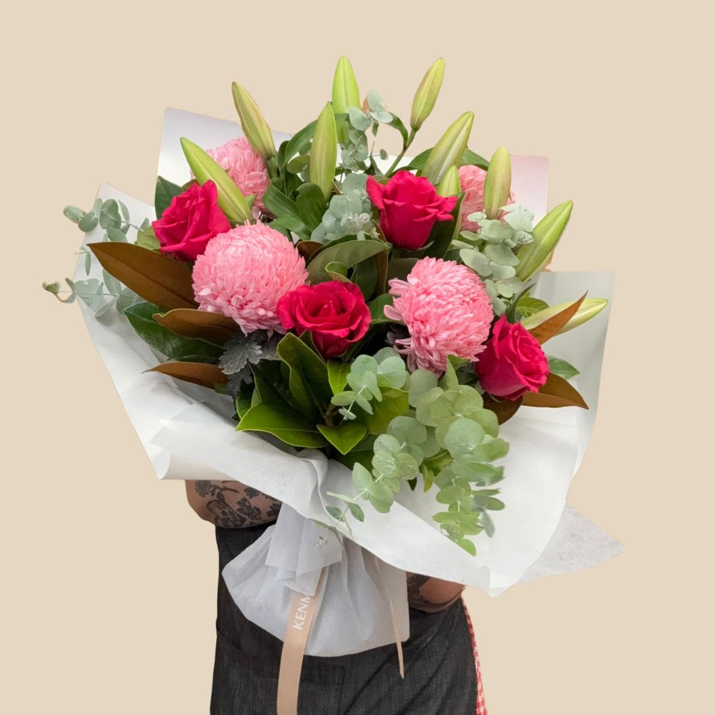 A bouquet of flowers including red roses, pink lilies and green foliage. Kenmore Village Florist. Brisbane Florist. Same day delivery.